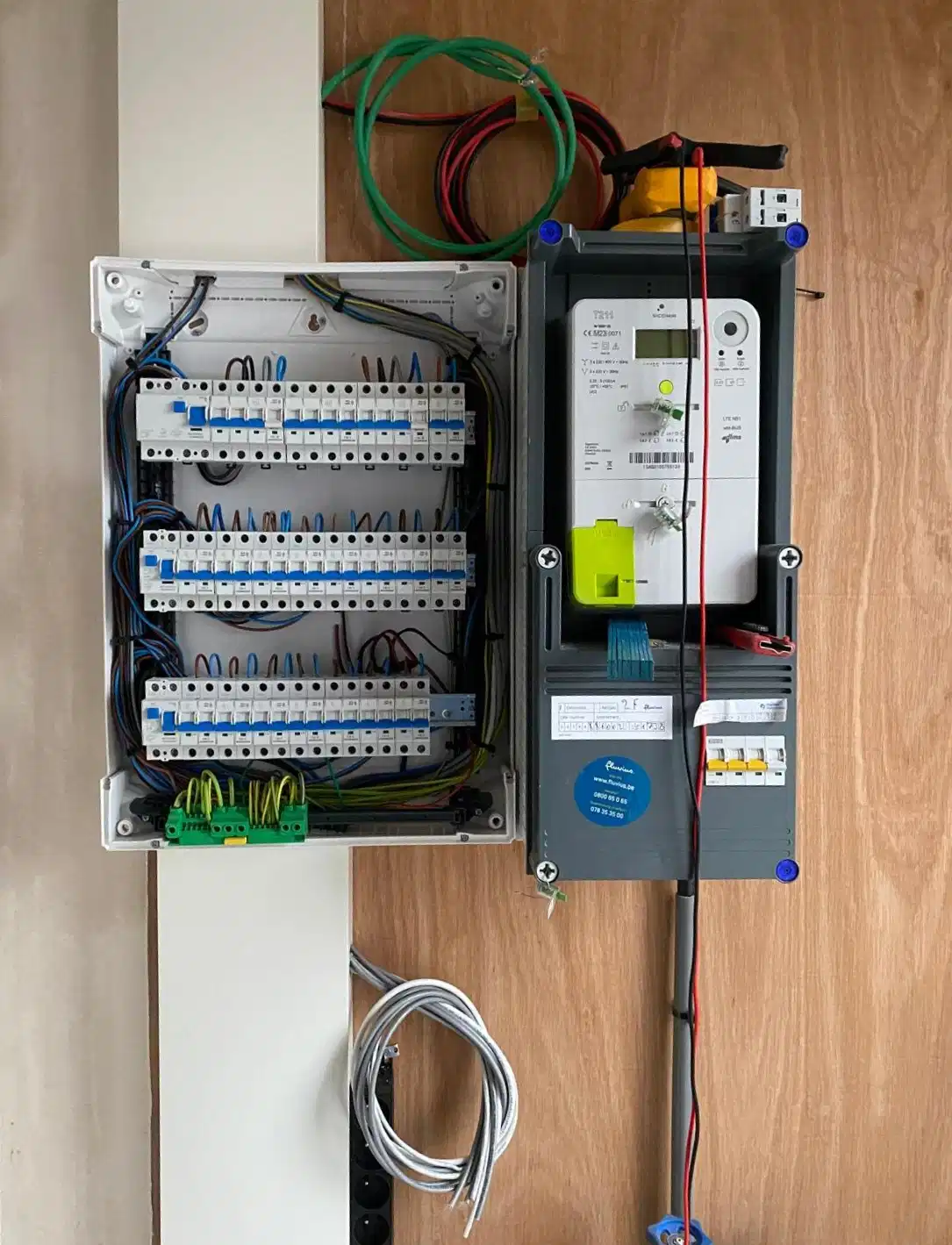 Nieuw geplaatste zekeringkast met drie rijen automaten naast de digitale meter